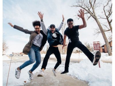 three students jumping